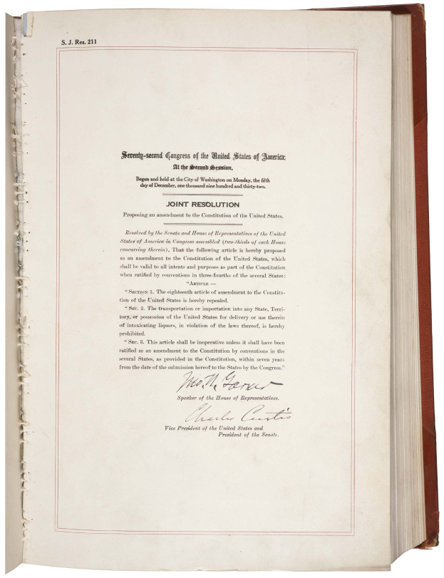 Ein aufgeschlagenes Buch mit rotem Rand auf einem weißen Hintergrund, das den Text "Gemeinsamer Beschluss des Zweiten Kongresses der Vereinigten Staaten von Amerika" zeigt.
