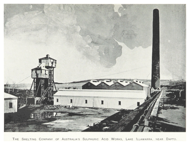 Schwarzes und weißes Foto einer industriellen Fabrik mit mehreren Gebäuden, einem hohen Turm und Rauch, der aus einem Schornstein austritt, mit Text unten.