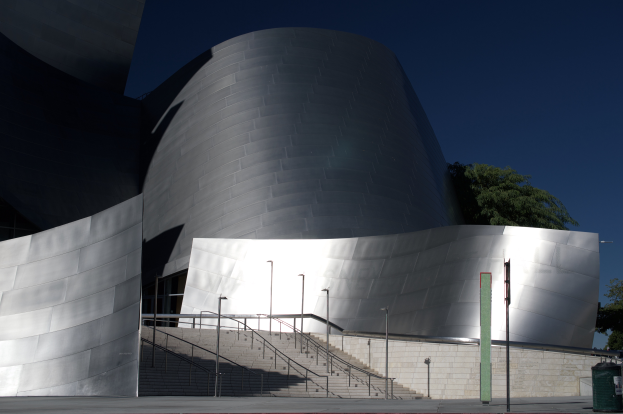 Das ARTIST Concert Hall in Los Angeles, ein großes Gebäude mit einer Treppe, die zum Eingang führt, umgeben von Straßenlaternen, Bäumen und einem Müllcontainer, unter einem bewölkten Himmel.