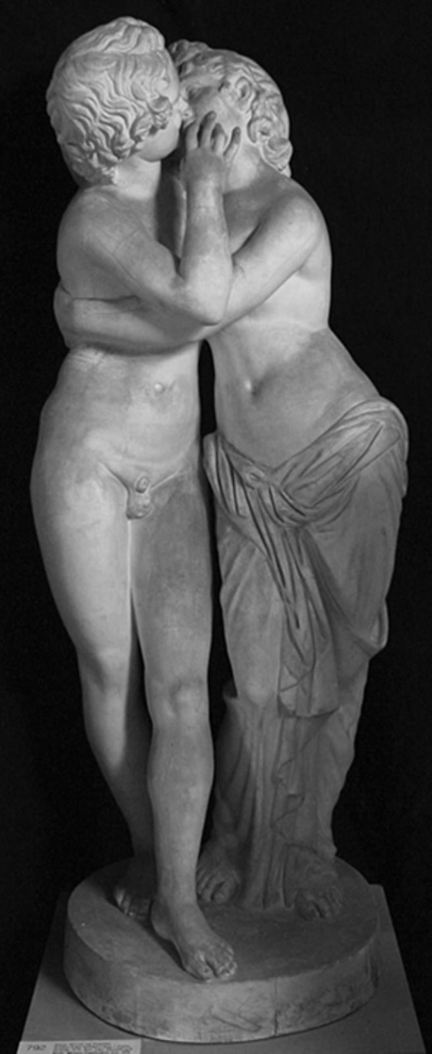 Eine schwarz-weiße Statue eines Mannes und einer Frau, die sich leidenschaftlich küssen und auf einem Sockel stehen.