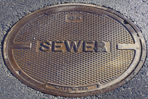 Metall-Schachtobjekt auf der Straße mit der geprägten Aufschrift "Kanal"