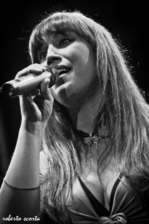 Eine Frau mit einem Mikrofon, die zu singen scheint.