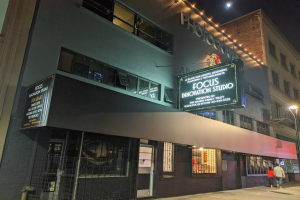 Außenansicht des Focus Innovation Studio in New York City bei Nacht, mit beleuchteten Fenstern, einem Gebäudenamensschild, Menschen auf dem Bürgersteig und dem Nachthimmel.