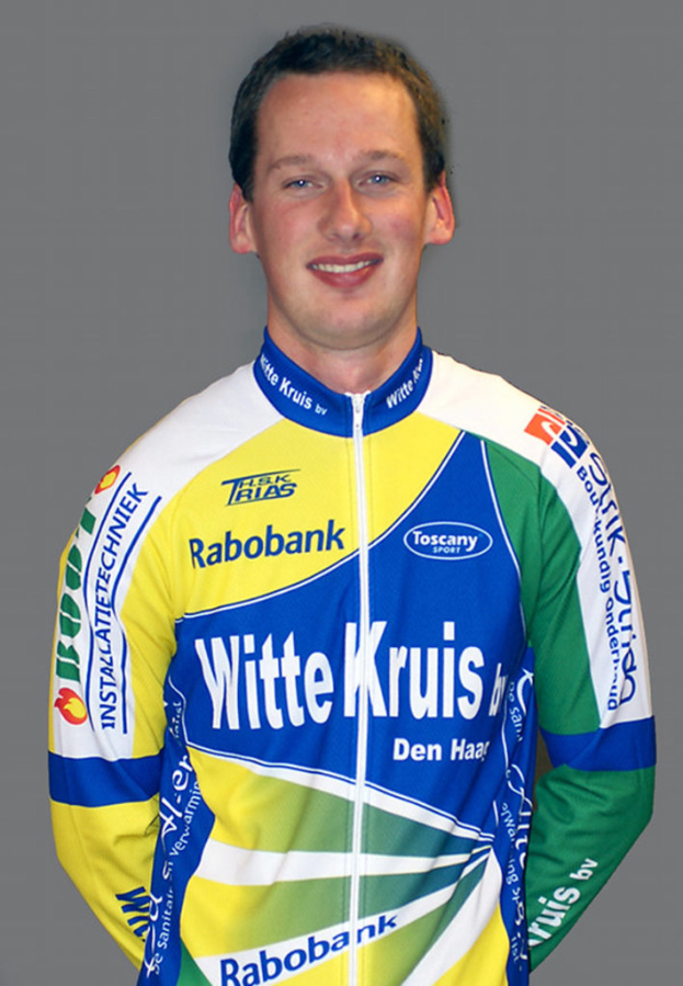 Ein Sportler posiert für ein Foto und trägt ein T-Shirt mit verschiedenen Sponsorennamen.