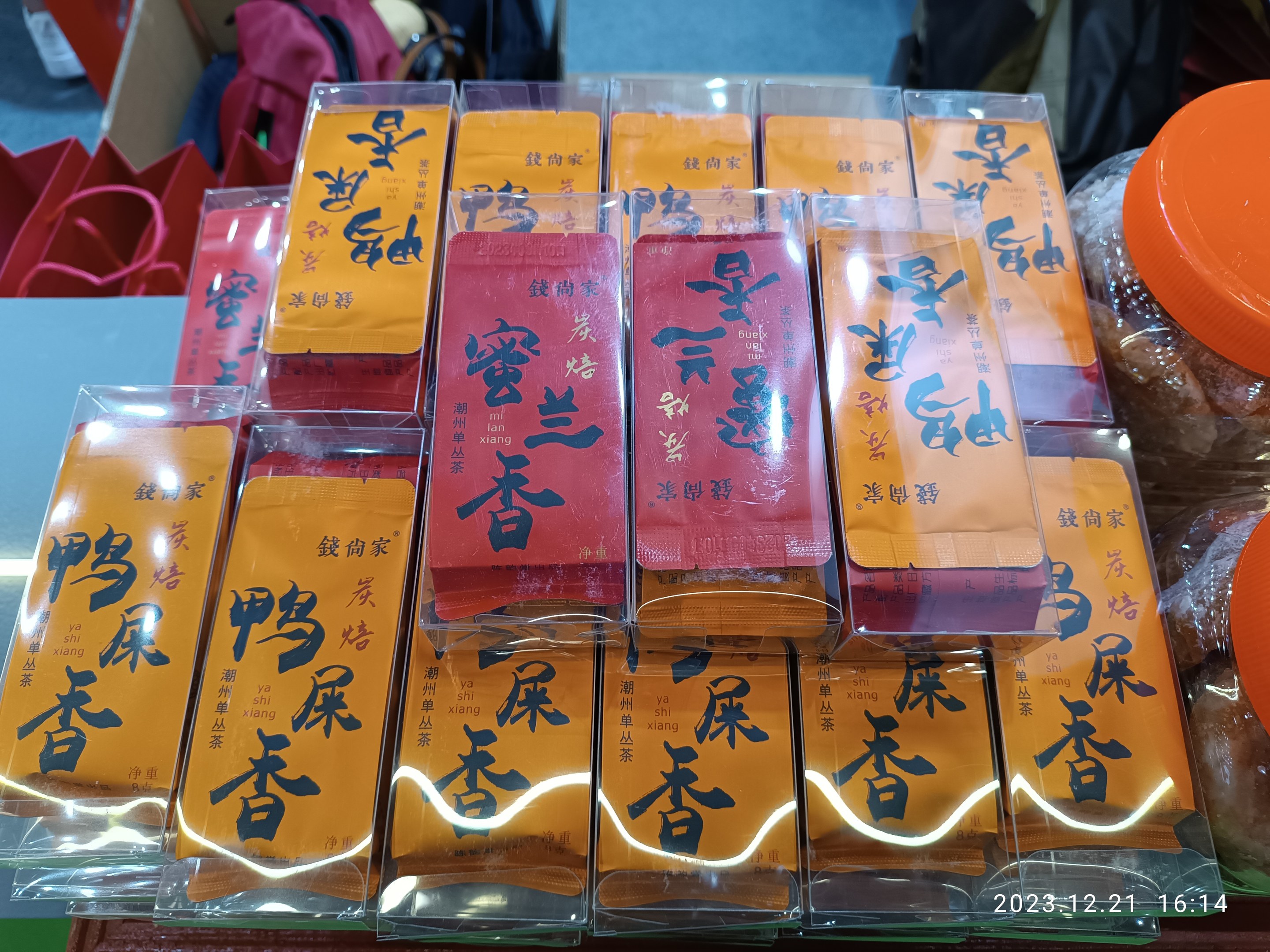 Ein Tisch voller verschiedener verpackter Lebensmittel und Gegenstände, mit einer Person im Hintergrund während eines chinesischen Neujahrsfests.