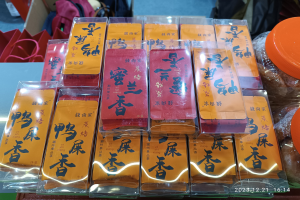 Ein Tisch voller verschiedener verpackter Lebensmittel und Gegenstände, mit einer Person im Hintergrund während eines chinesischen Neujahrsfests.