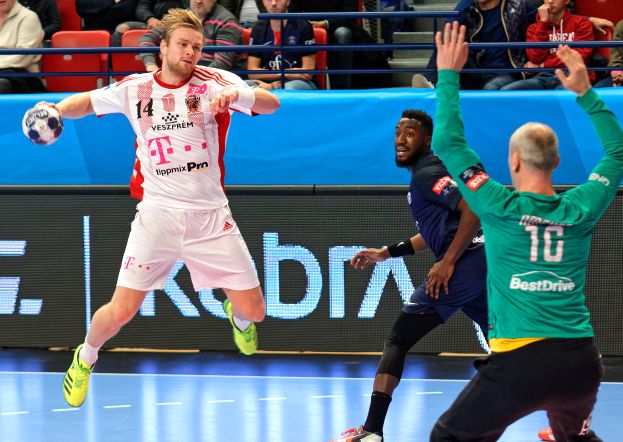 Eine Gruppe von Männern, die Handball auf einem Platz spielen, mit einem Ball in der Mitte der Aktion und Zuschauern im Hintergrund, die das Spiel beobachten, das Teil der Futsal-Weltmeisterschaft 2019 zwischen Bayern München und Paris Saint-Germain ist.