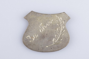 Silberne Anstecknadel mit Lorbeerkranz und der Aufschrift "50. Hochzeitstag" auf weißem Hintergrund.