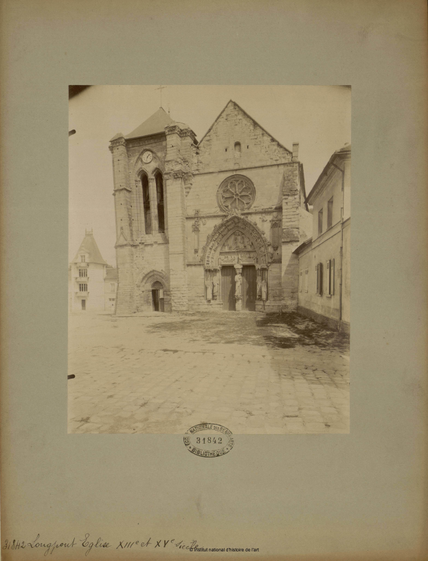 Ein altes Foto einer Kirche inmitten einer Straße, gerahmt in einem Fotorahmen, umgeben von anderen Gebäuden in einer belebten Stadtkulisse.