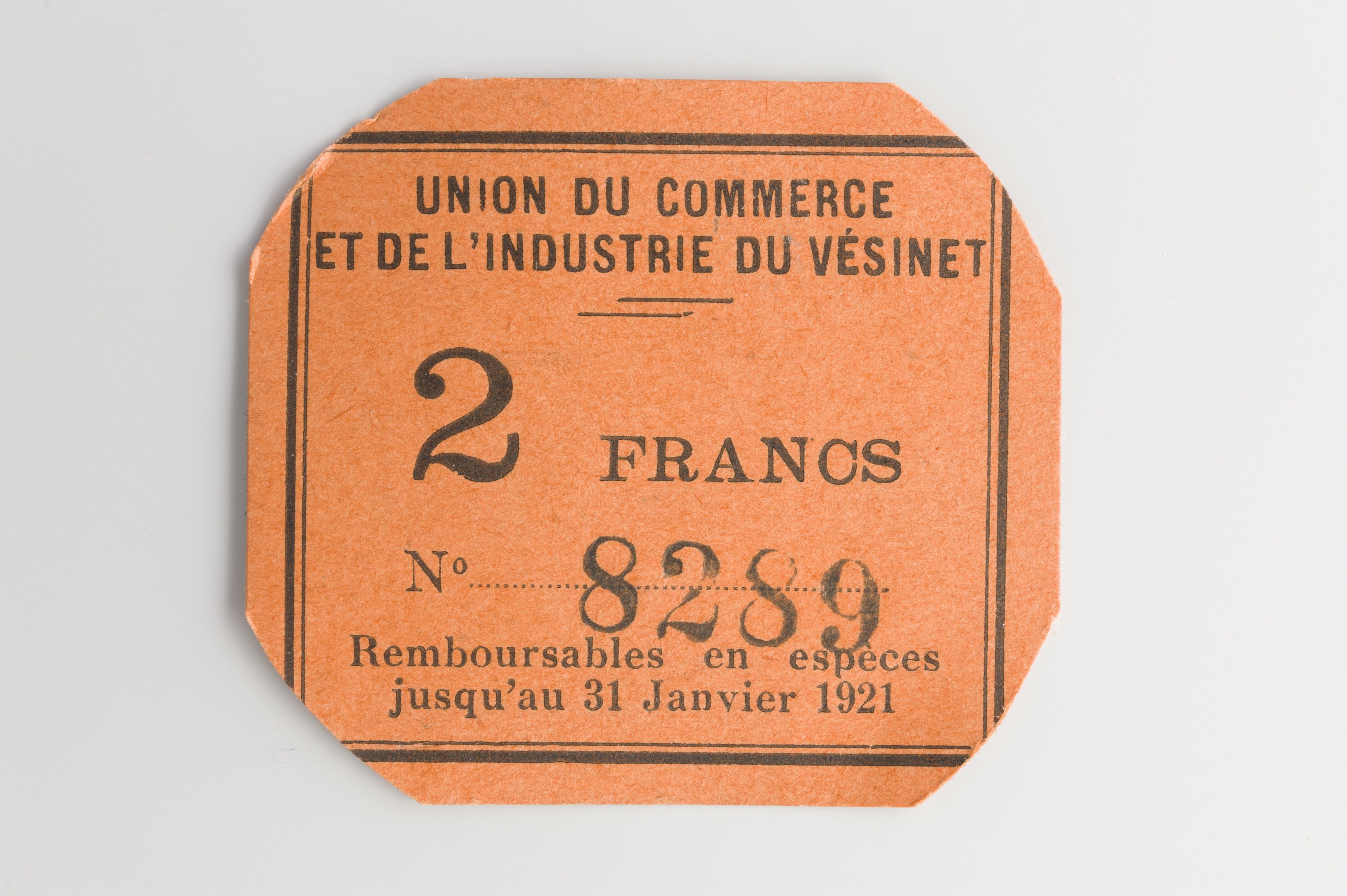Orange Ticket mit "Union du Commerce et de l'Industrie du Vésinet" darauf gedruckt, vor einem weißen Hintergrund.