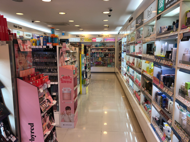 Ein mit verschiedenen Kosmetik- und Haarpflegeprodukten gef├╝llter Laden, der auf Regalen und dem Boden angeordnet ist, mit Informationsschildern an den W├Ąnden und Deckenleuchten.