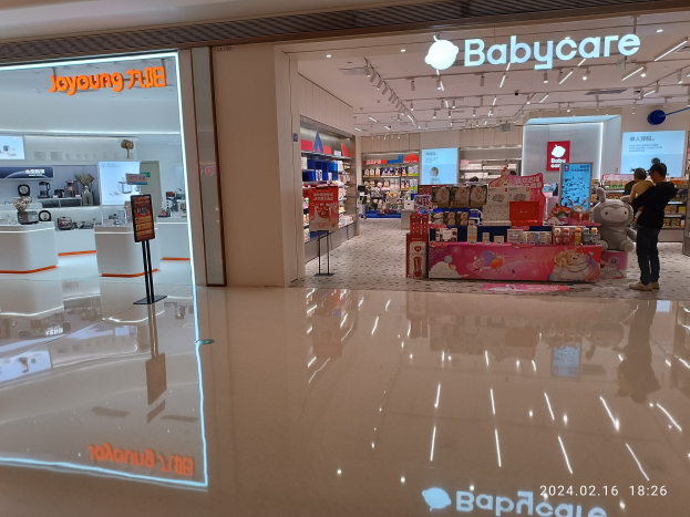 Babycare-Laden in einem Einkaufszentrum mit Spielzeugen, Regalen, Schildern, einem Anzeigebildschirm und Deckenleuchten, gelegen im Mall of Asia.