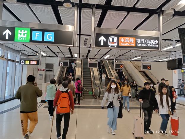 Menschen mit Gepäck durch einen geschlossenen Flughafen gehen, Rolltreppen, Informationsanzeigen und Glaswände im Hintergrund sichtbar