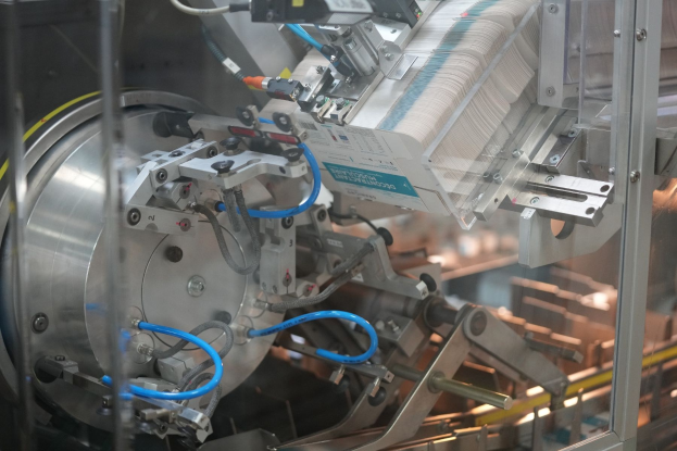 Automatisiertes Verpackungssystem auf einem Fabriktisch mit leicht unscharfen Hintergrundobjekten.