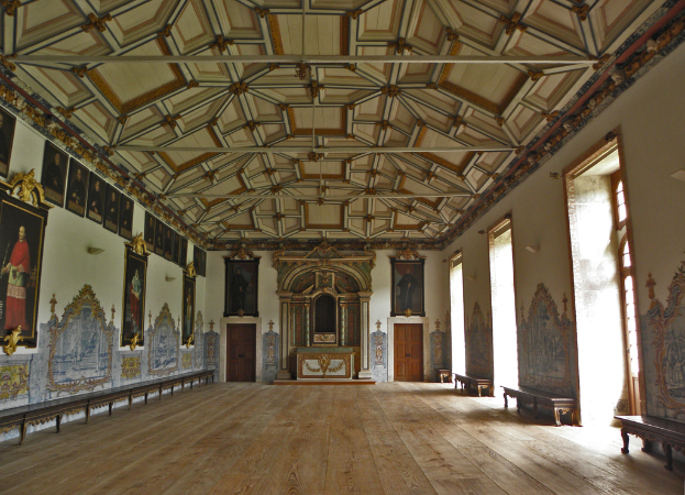 Ein Innenblick in einen Saal mit Rahmen, Kunst, Türen, Fenstern und Bänken an den Wänden.