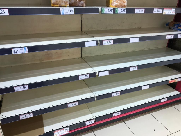 Leere Supermarktregale in einer Reihe mit sichtbarem Boden.