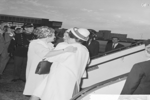 Königin Elizabeth II. und Prinz Philip, Herzog von Edinburgh, beim Ankunft am Heathrow Airport in London, mit zwei Frauen, die sich umarmen und ein Mann, der eine Kamera hält, in in Hintergrund.