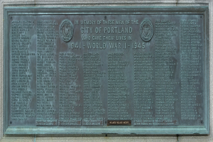 Plakette an der Seite eines Geb├Ąudes mit der Aufschrift "Denkmal für die Stadt Portland" in fetter schwarzer Schrift, an einer Wand mit einem dekorativen Rahmen angebracht.