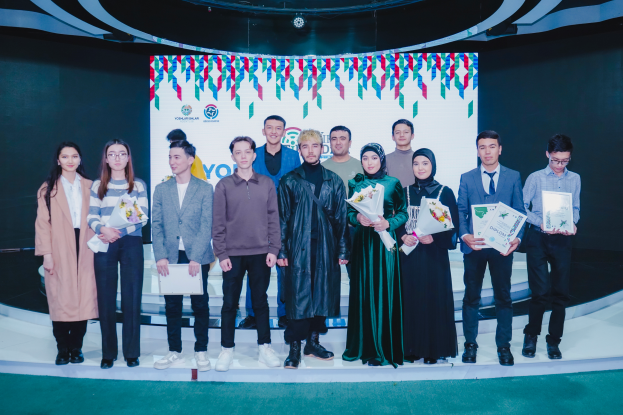 Eine Gruppe von Menschen auf einer Bühne mit Blumensträußen und Urkunden, im Hintergrund ein Schild "Youth Solar Awards 2019"