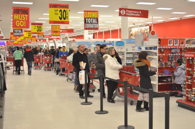Ein volles Walmart-Geschäft mit Einkaufswagen schiebenden Kunden und Menschen mit Taschen.