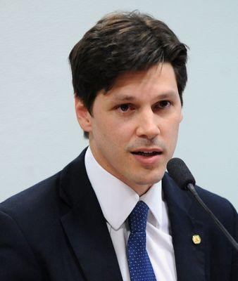 Ein Mann im Anzug spricht in ein Mikrofon, wahrscheinlich zur Genehmigung eines Gesetzes durch die Regierung.