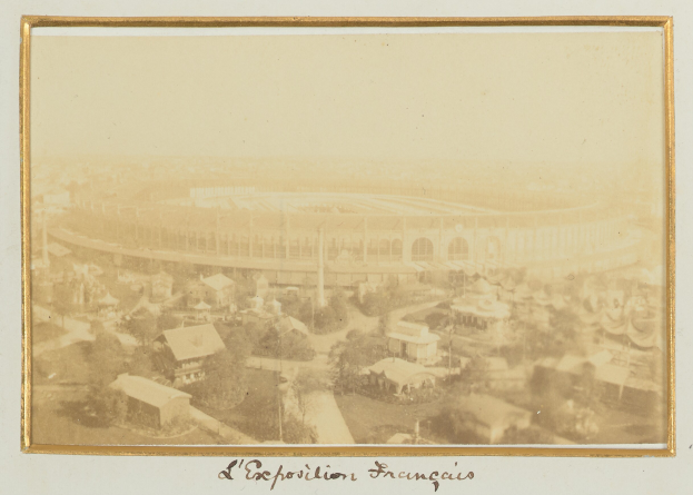 Altes Schwarz-Weiß- Foto eines Stadions in einer urbanen Umgebung mit umliegenden Gebäuden, Bäumen und Masten, mit Text unten.